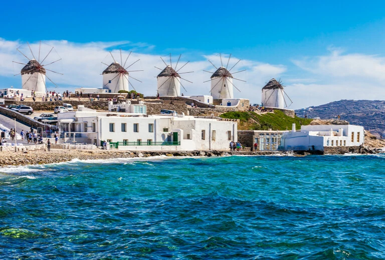 Point de vue emblématique des moulins à vent lors d'une journée ensoleillée d'été claire et lumineuse le long de la mer bleue et des côtes de Mykonos, Grèce"