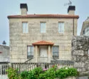 Une traditionnelle maison de manoir galicienne avec des murs en pierre et un toit en tuiles.